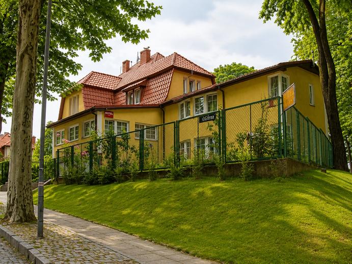 Ciche brukowane wejście prowadzące do dziedzińca Hotelu Pod Platanami